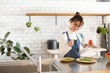 女孩在厨房烹饪蔬菜图片
