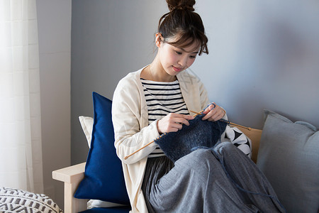 编织沙发客厅沙发上编织毛线的少女背景