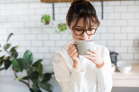 厨房里喝水的居家女性图片