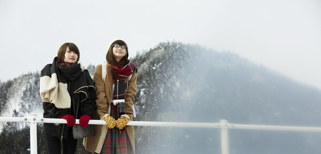 靠着围栏的女性下雪的高清图片素材