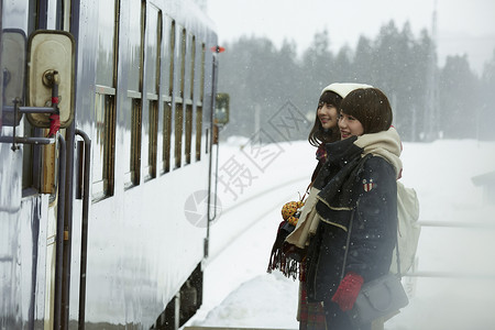 冬季在雪地里等车的女孩朋友高清图片素材
