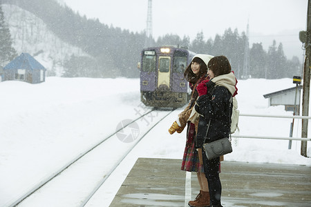 冬天下雪天在雪地里漫步的女学生等列车亲密高清图片素材