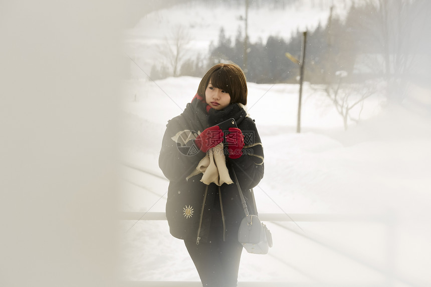 冬天在雪地里漫步的女学生图片