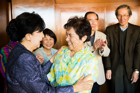 室内中老年人校友会团聚老朋友握手问候背景图片