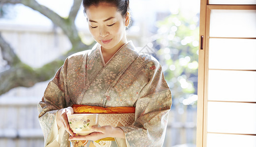 成就日本茶饭碗享受茶道的妇女图片