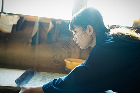 年轻学徒拿着传统的手工印花染布图片