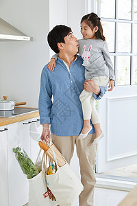 拿着购物袋抱着女儿的父亲图片