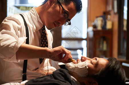 剪眼镜男年轻人剃须理发师刮男客人图片