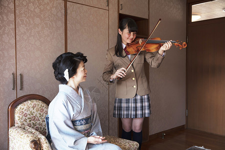 指示母亲教师丰富的家庭小提琴表演图片