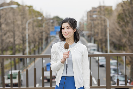 室外播报广播的女记者背景图片