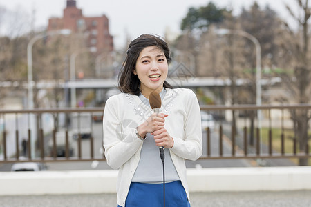 寒冷天气播报新闻的女青年图片