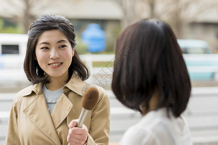 拿着话筒街头采访的女播音员图片