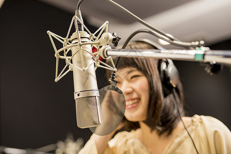 录音棚里录音开心的女播音员器具高清图片素材