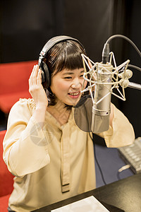 带着耳机对着麦克风录音的女性日本人高清图片素材