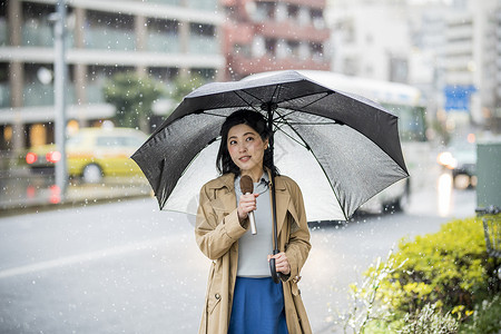 户外播报新闻节目的女记者背景图片