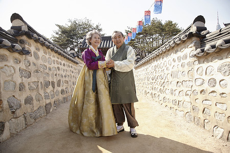 传统村庄穿着传统服装散步的老年夫妇图片