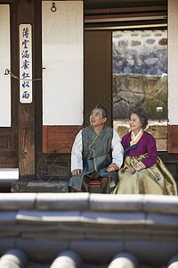 民俗村坐在屋外穿着传统服装的夫妻图片