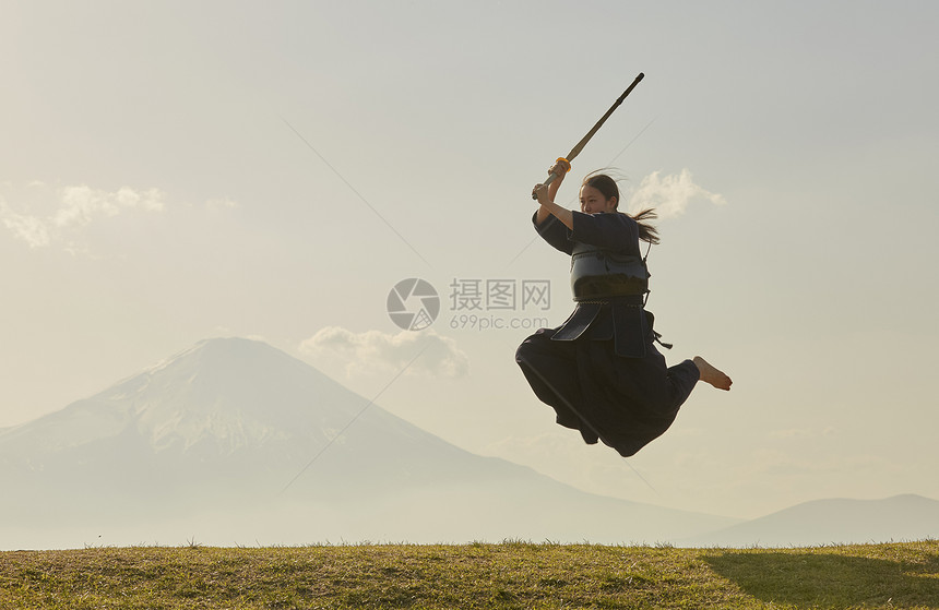 户外练习剑道跳跃的少女图片