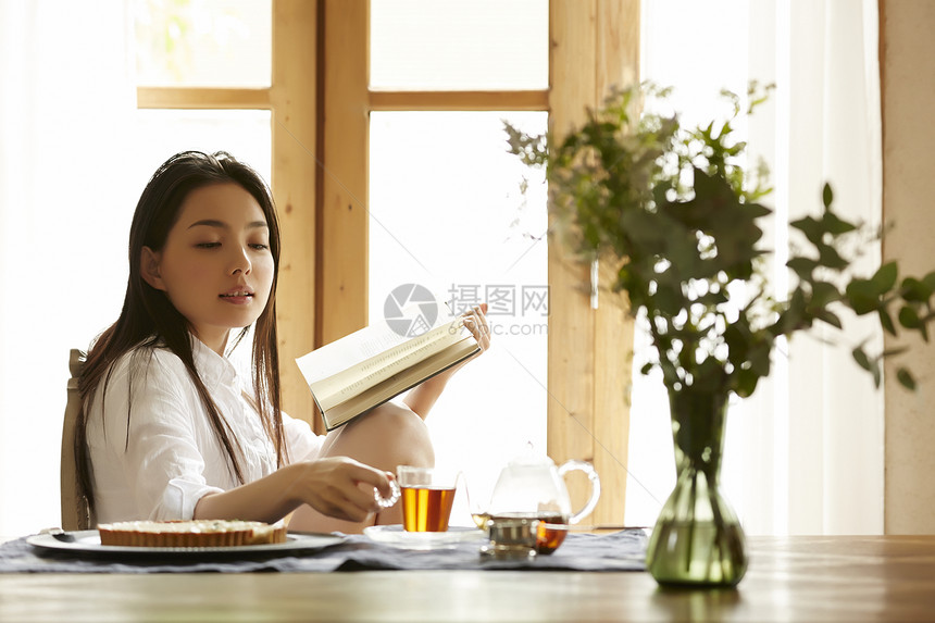 居家阅读享受下午茶的年轻女性图片