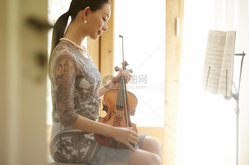 拿着小提琴的成熟气质女性图片