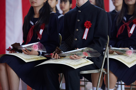 手捧鲜花的参加毕业典礼的学生花束高清图片素材