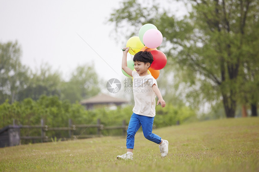 拿着气球奔跑的小男孩图片