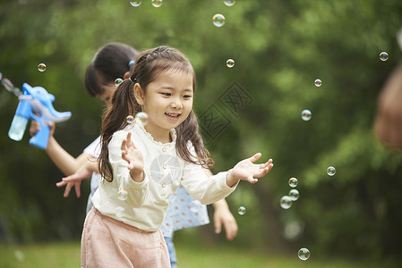 公园里玩泡泡的小女孩图片