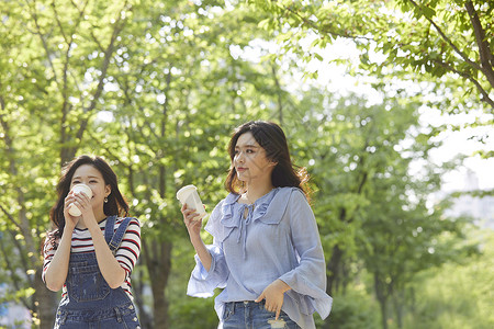 和朋友一起喝咖啡聊天的年轻女子图片