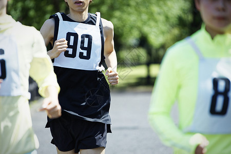 戴着号码牌奔跑的参赛者背景图片