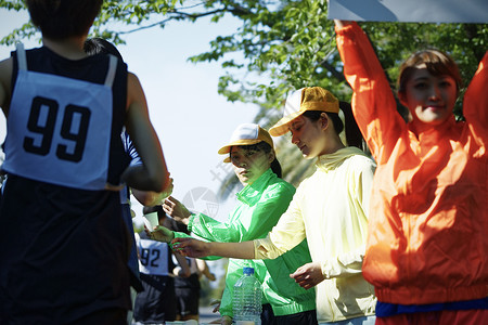 户外的马拉松供水站拿水的参赛者图片