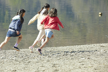 假期户外活动小学生在河边奔跑伙伴高清图片素材