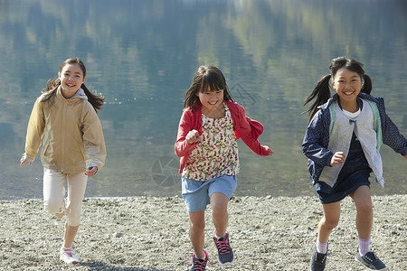 假期户外活动小学生在河边奔跑比赛高清图片素材