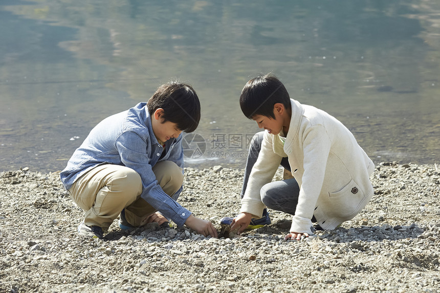 假期户外活动小学生在河边玩图片