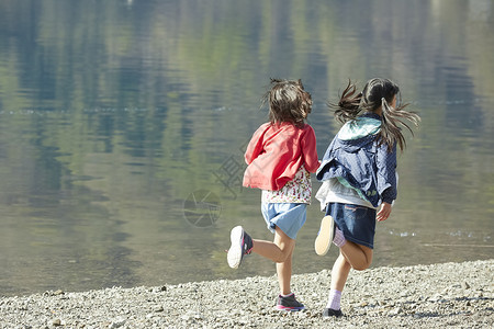 假期户外活动小学生在河边奔跑享受高清图片素材