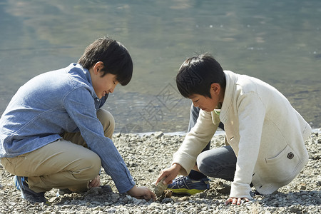 蹲在岸边玩耍的小男孩们图片