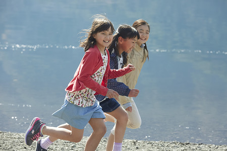 湖边玩耍奔跑的孩子们夏天高清图片素材