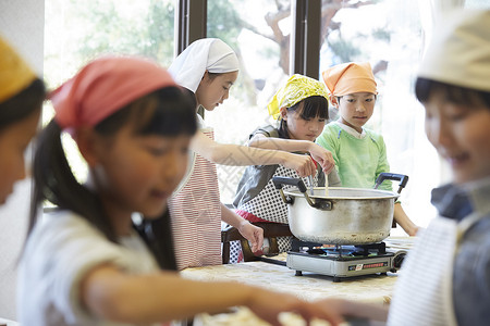 小学生在学校里学习烹饪练习高清图片素材