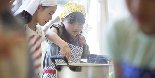 学校里学习做饭的小学生朋友高清图片素材