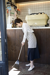 咖啡馆打扫卫生扫地的年轻女性图片