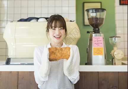 咖啡店女职员手拿面包图片