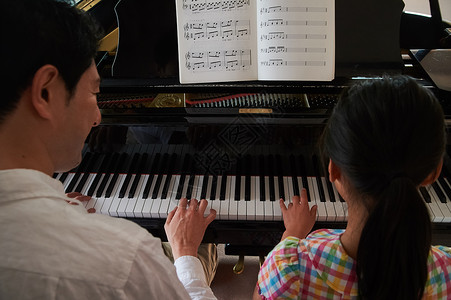 年轻的女孩学习钢琴课高清图片