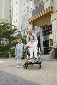 爷爷和小女孩推着轮椅上的奶奶图片