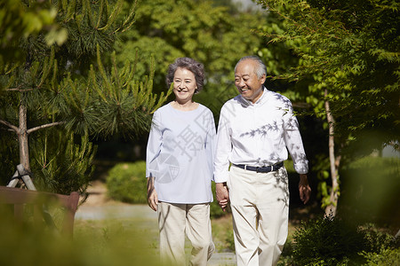 手牵手户外散步的老年夫妇图片