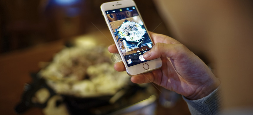 手机拍摄食物照片的特写图片