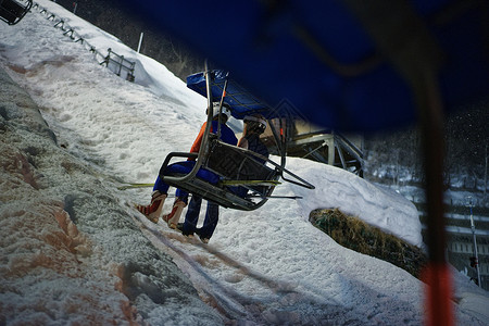 夜晚滑雪场坐着缆车上山的运动员图片