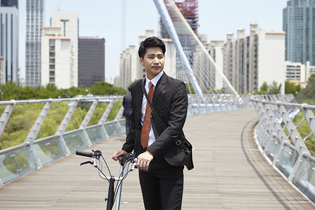 扶着自行车的行走的成年男子图片