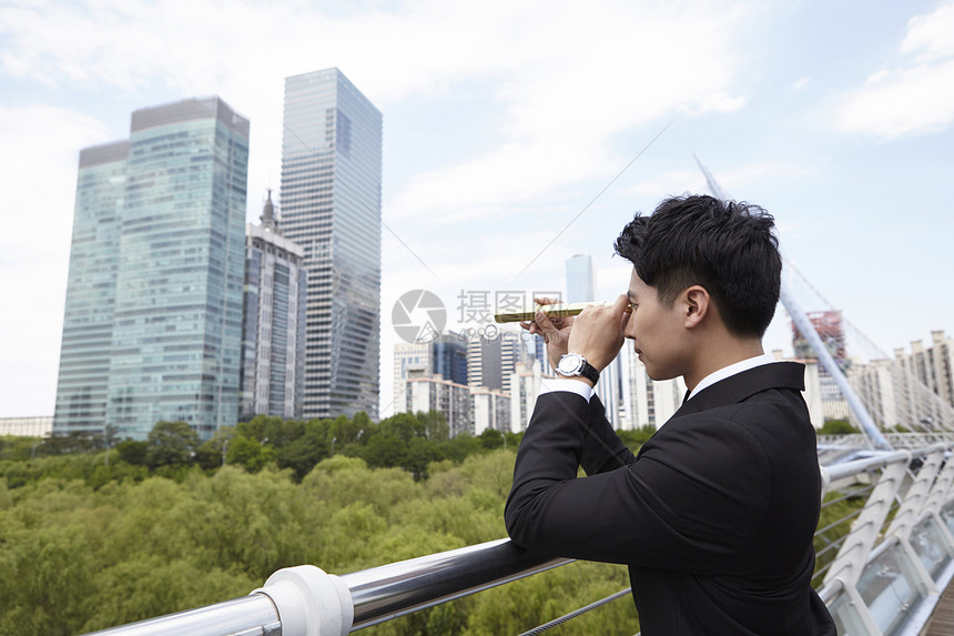 户外拿着望眼镜的商务人士图片