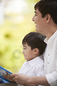 父母在陪伴孩子看童话书背景图片