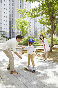 女子玩滑板父母陪着孩子玩滑板背景