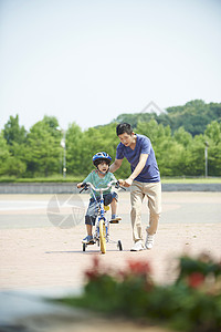 陪儿子练习骑车的爸爸图片